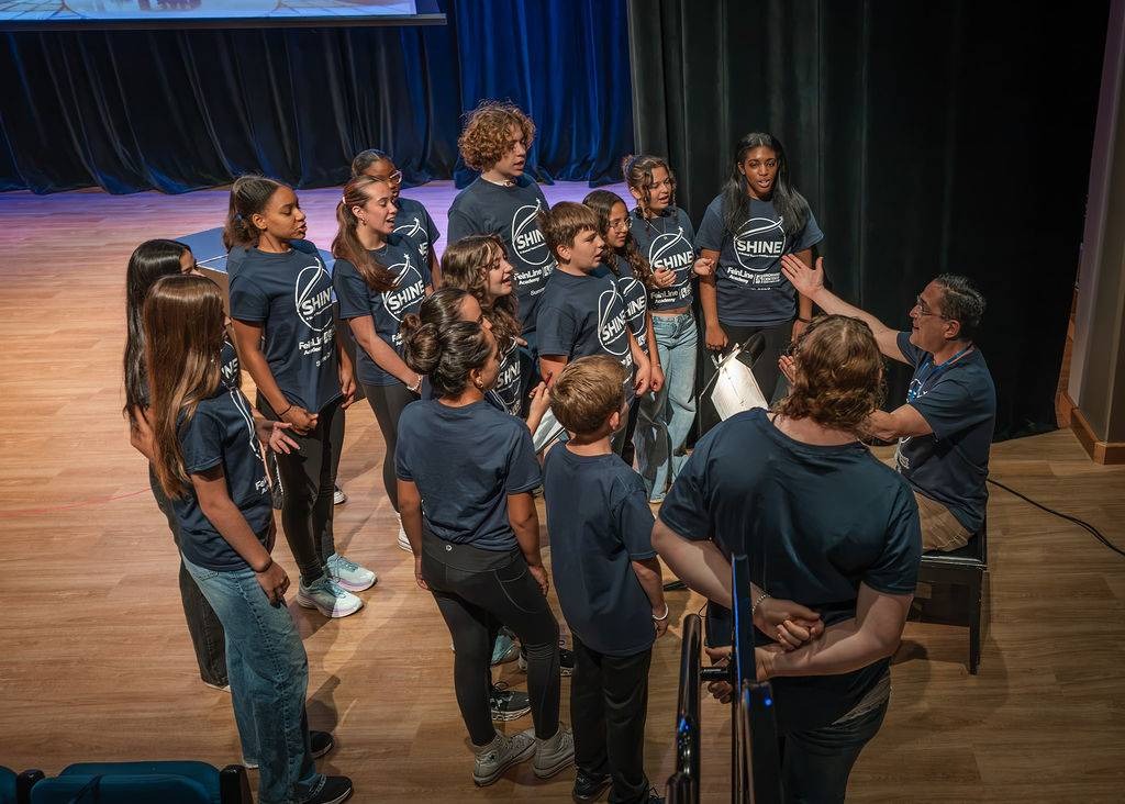 Brian leading the ensemble in song on stage