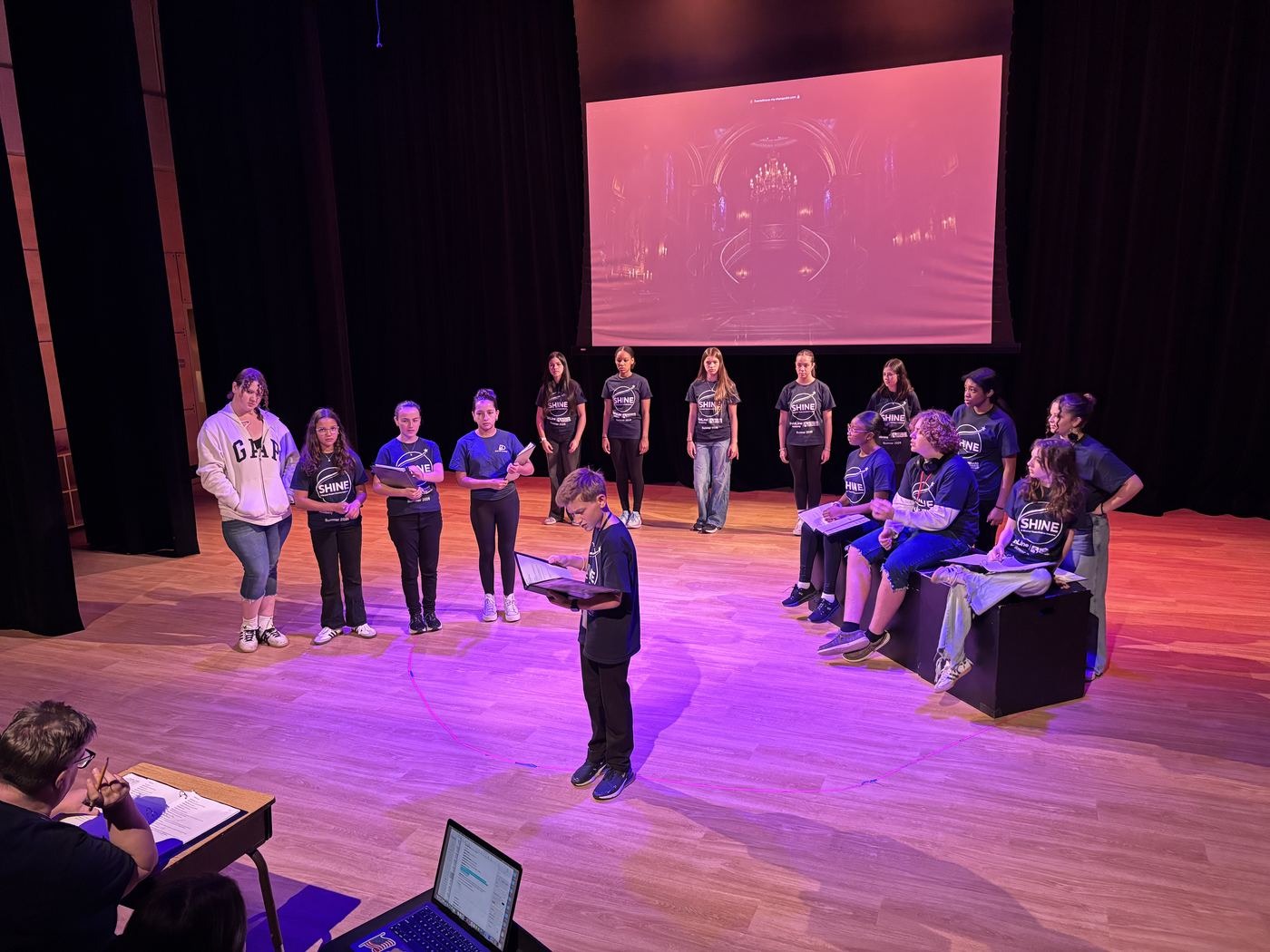 Full cast in rehearsal on stage
